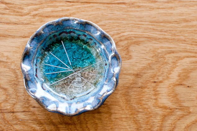 Acupuncture needles on blue dish
