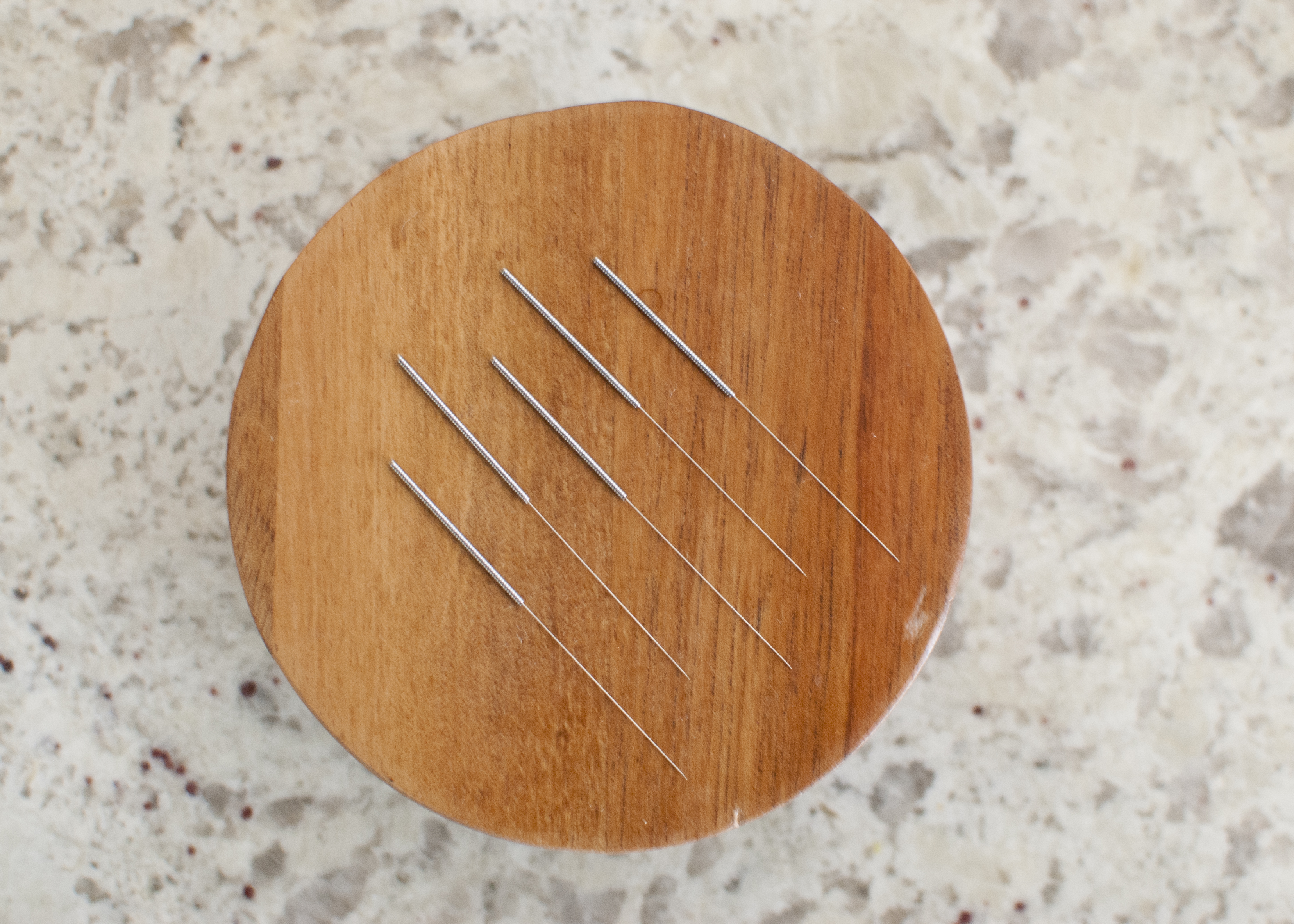 Acupuncture needles on round lid